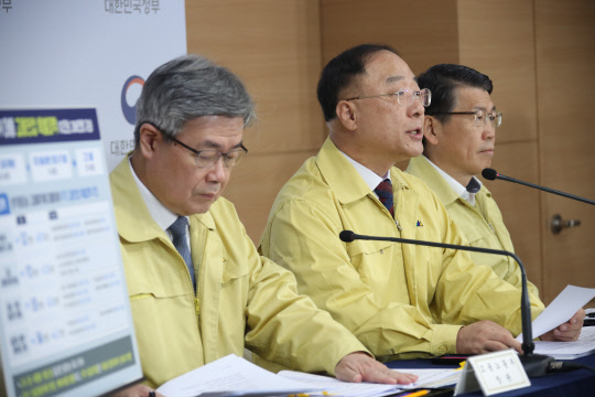 홍남기 경제부총리 겸 기획재정부 장관과 이재갑 노동부 장관(왼쪽), 은성수 금융위원장(오른쪽)이 22일 정부서울청사 브리핑실에서 제5차 비상경제회의를 마치고 결과 합동브리핑을 하고 있다. <연합뉴스>